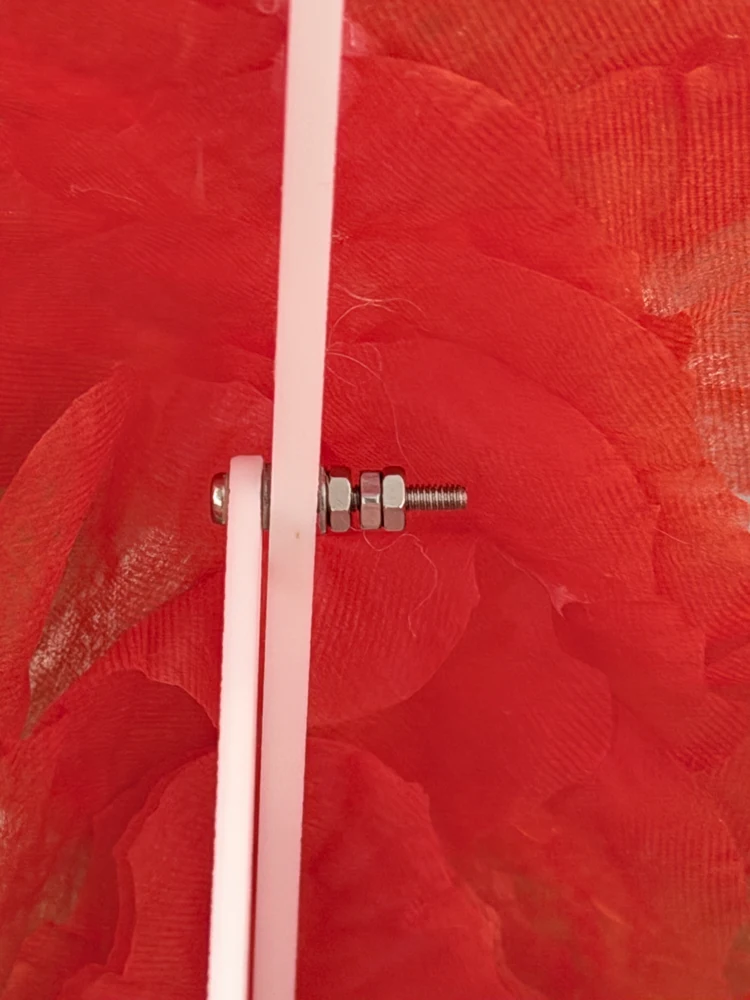 Close-up of a petal support bolted in place with washers and nuts